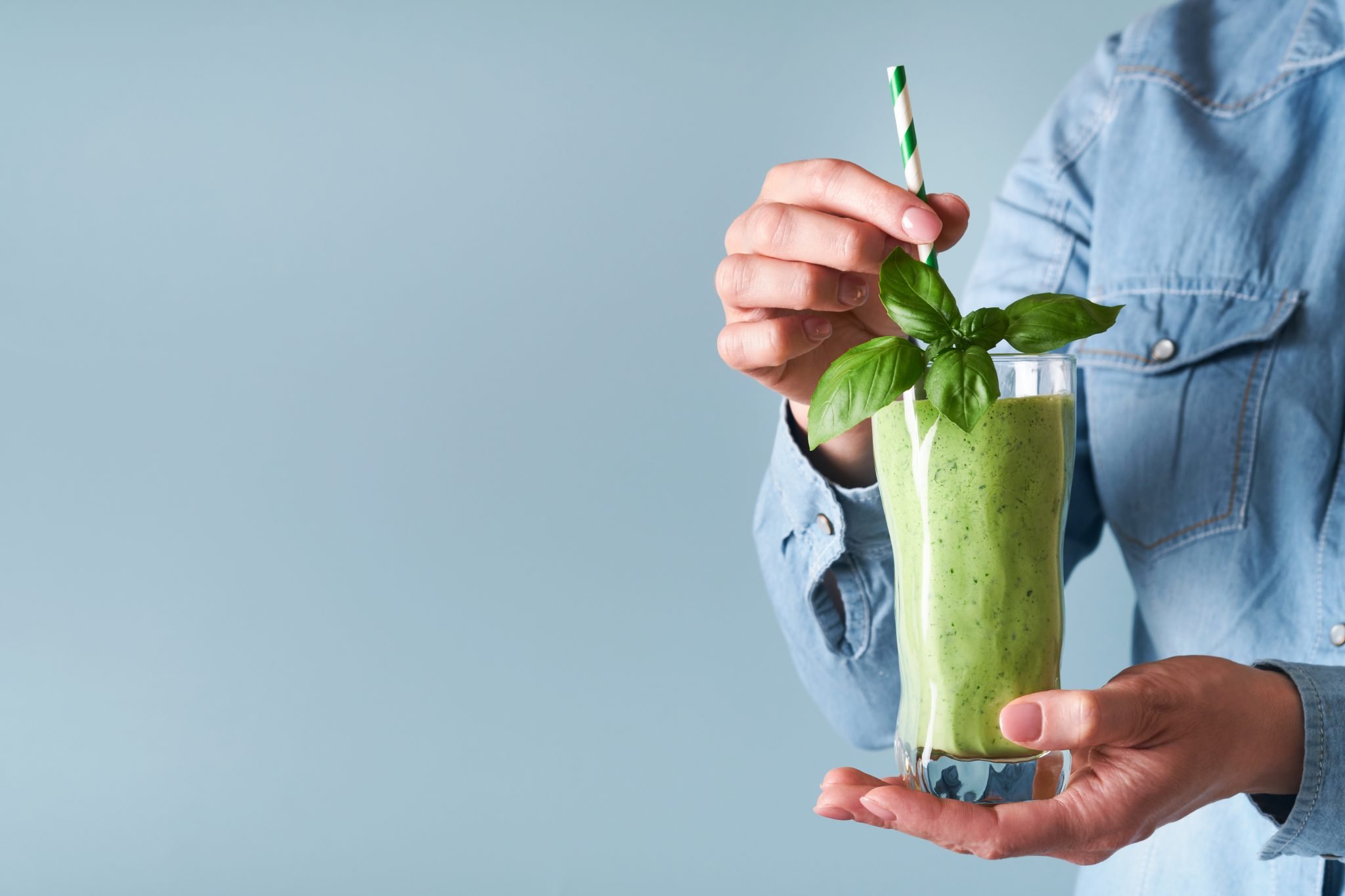 A woman drinking a green smoothie