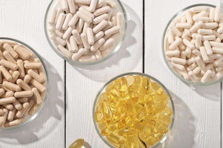 Different tablets and capsules in bowls.
